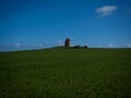 Panorama view of old rustic historic windmill Moulin de Moidrey in green grass field meadow Pontorson Normandy France