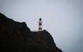 Panorama view of red and white stripes lighthouse on top of oceanside cliff hill, Cape Palliser Wellington New Zealand Royalty Free Stock Photo