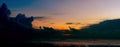 Panorama view of sea at tide and silhouette dramatic sunset sky and clouds in the evening with light on the road at seaside of the Royalty Free Stock Photo