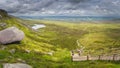 Panorama with view on steep stairs of wooden boardwalk leading to Cuilcagh Mountain peak with lake and valley below Royalty Free Stock Photo