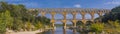 Panorama view to the lime stone Pont du Gard three-tiered aqueduct at the river Gardon.