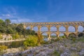 Panorama view to the limestone Pont du Gard three-tiered aqueduct at the river Gardon. Royalty Free Stock Photo