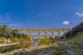 Panorama view to the limestone Pont du Gard three-tiered aqueduct at the river Gardon.