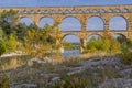 Panorama view to the limestone Pont du Gard three-tiered aqueduct at the river Gardon.