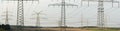 Panorama view to many electric pylons Royalty Free Stock Photo