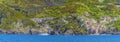 A panorama view towards the two halves of the Cinque Terre village of Riomaggiore, Italy and surrounding cliffs Royalty Free Stock Photo