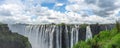 Victoria Falls of Zambezi River, border of Zambia and Zimbabwe with blue sky and dramatic clouds Royalty Free Stock Photo