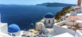 A panorama view of white painted houses and blue domed churches in the village of Oia, Santorini with Thirasia island Royalty Free Stock Photo