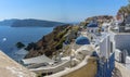 A panorama view of white painted houses, pathways and blue domed churches in the village of Oia, Santorini Royalty Free Stock Photo