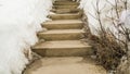 Panorama Weathered concerete outdoor steps amid snow covered slope in winter