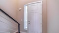 Panorama White hinged wooden front door and sidelight viewed from inside of home