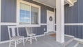 Panorama White porch chairs against window and front door of home with gray exterior wall Royalty Free Stock Photo