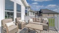 Panorama White puffy clouds Outdoor patio on a wooden deck with cushioned woven sofa and arm