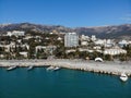 The panorama of Yalta city and the Crimean mountains. Aerial view of embankment and skyline at sunny spring day from sea