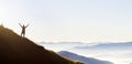 Panorama of young successful man hiker silhouette open arms on mountain peak. Royalty Free Stock Photo
