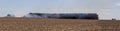 Panoramatic view to stack hay in fire on field with firemans