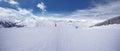 Panoramaview to ski slopes and skiers skiing in Kitzbuehel mountain ski resort with a background to Alps in Austria