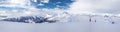 Panoramaview to ski slopes and skiers skiing in Kitzbuehel mountain ski resort with a background to Alps in Austria Royalty Free Stock Photo