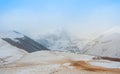 Panoramic aerial top view to a path and winter Caucasian mountains covered with snow and glaciers near Gergeti Trinity church Royalty Free Stock Photo