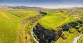 aerial view of agricultural fields sown with crops and river in deep canyon. Fertile farmland and soil erosion concept