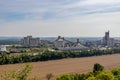 Panoramic aerial view of cement factory next to an agricultural field after harvesting