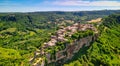 Panoramic aerial view of Civita di Bagnoregio from a flying drone around the medieval city, Italy