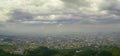 Panoramic aerial view of hazy city with smokestacks under cloudy sky