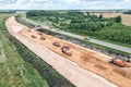 Panoramic aerial view of large road construction site with working heavy machines