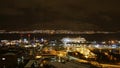 Panoramic aerial view of northern TromsÃÂ¸ by night with illuminated streets and buildings and Aida cruise ship at anchor.