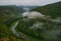 Panoramic aerial view over the top of a summer landscape of a green hills, a large river, and a forest belt at sunset Royalty Free Stock Photo