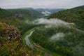 Panoramic aerial view over the top of a summer landscape of a green hills, a large river, and a forest belt at sunset Royalty Free Stock Photo