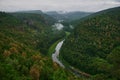 Panoramic aerial view over the top of a summer landscape of a green hills, a large river, and a forest belt at sunset Royalty Free Stock Photo