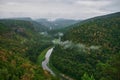 Panoramic aerial view over the top of a summer landscape of a green hills, a large river, and a forest belt at sunset Royalty Free Stock Photo