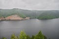 Panoramic aerial view over the top of a summer landscape of a green hills, a large river, and a forest belt at sunset Royalty Free Stock Photo