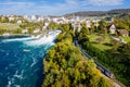 Panoramic aerial view of Rhine Falls and cityscape of Neuhausen am Rheinfall town, Switzerland. Red Swiss train, and tourist boats Royalty Free Stock Photo