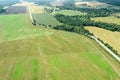 Panoramic aerial view of summer rural scenery, farmland, country road among fields