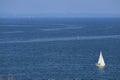 Panoramic aerial view of a white sailboat on the blue calm sea