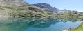 Panoramic: the alpine mountain reflected in the blue water of the lake