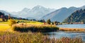 Panoramic autumn scene of Haidersee Lago della Muta lake with Ortler peak on background. Breathtaking morning view of Italian Al