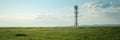 Panoramic banner of industrial communication tower for signal transmitter in a sunny meadow