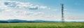 Panoramic banner of industrial communication tower for signal transmitter in a sunny meadow