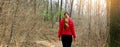Panoramic banner view of lost woman walking alone on a forest path in autumn or winter Royalty Free Stock Photo