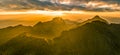 Panoramic beautiful mountain peaks topped with sky, cloud and blast horizon sun, and decorated with camera flares Royalty Free Stock Photo