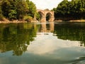 A panoramic of a beautiful stone bridge with two arches at the mouth to the estuary of the Galician coast bathed by the Atlantic