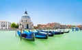 Panoramic view of traditional venetian gondolas moored in water of Grand Canal in front of Basilica di Santa Maria della Salute