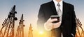 Panoramic, Businessman using mobile phone with Telecommunication towers with TV antennas and satellite dish in sunset