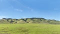 Panoramic view of central california hills after recent rains promoting green pastures