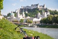 Salzburg summer time: Panoramic city landscape with Salzach with green grass and historic district. Bicycle in the foreground