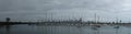 Panoramic of city of Melbourne against a sunny blue sky seen from St Kilda pier looking through the masts of yachts in the bay