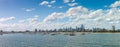 Panoramic of city of Melbourne against a sunny blue sky seen from St Kilda pier looking through the masts of yachts in the bay